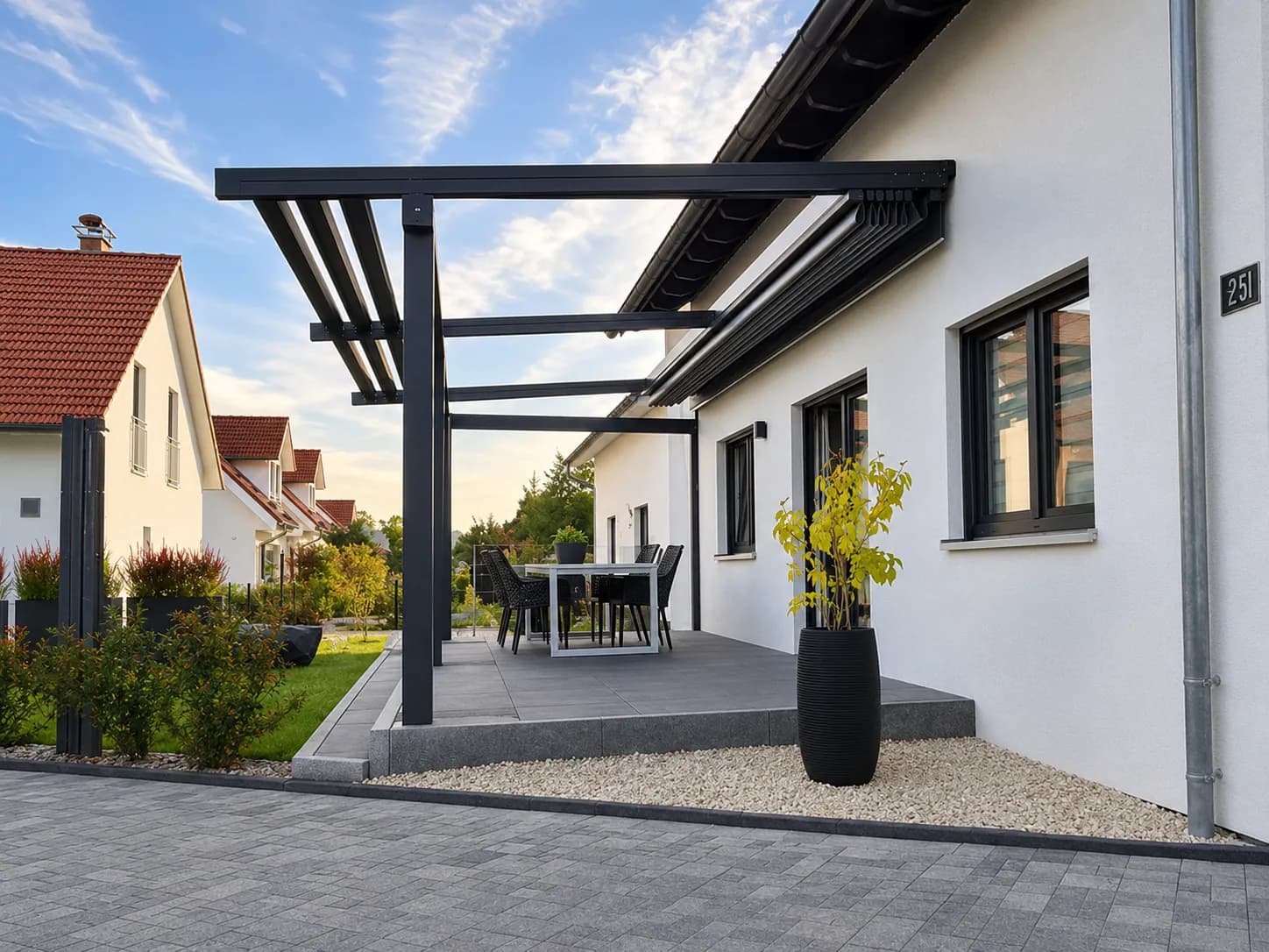 Terrassenüberdachung aus Glas und Aluminium mit Essplatz an einem Wohnhaus