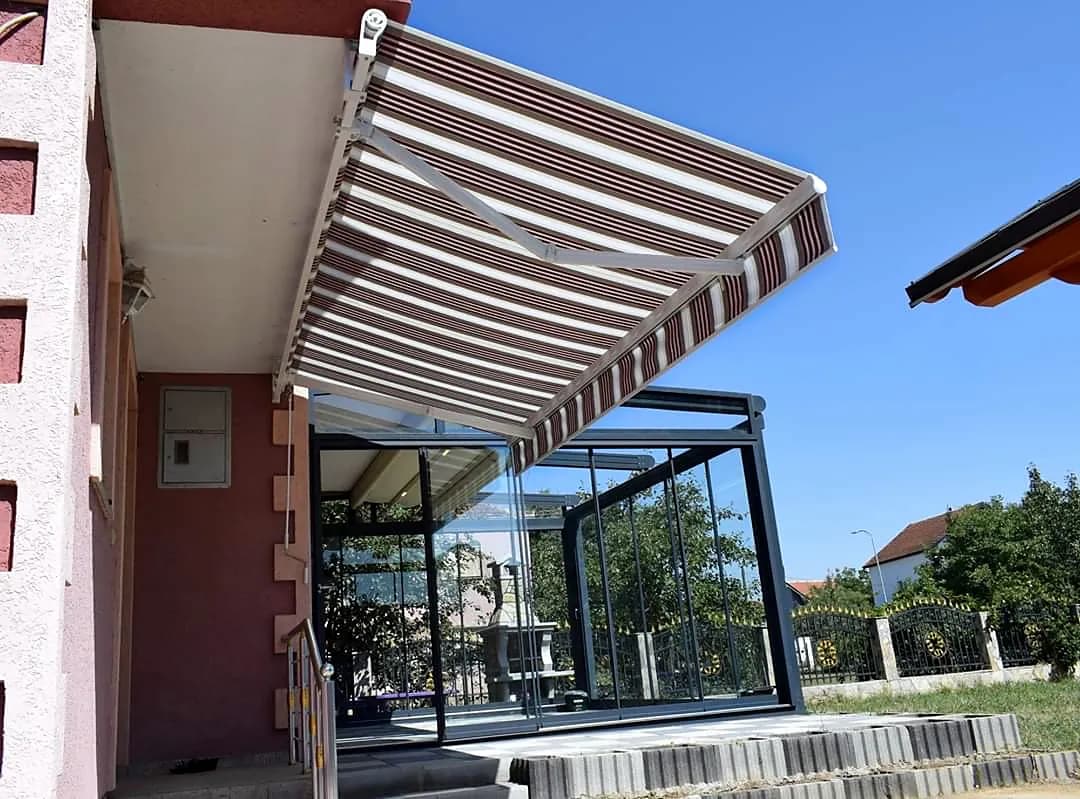 Gestreifte Gelenkarmmarkise über einem Balkon